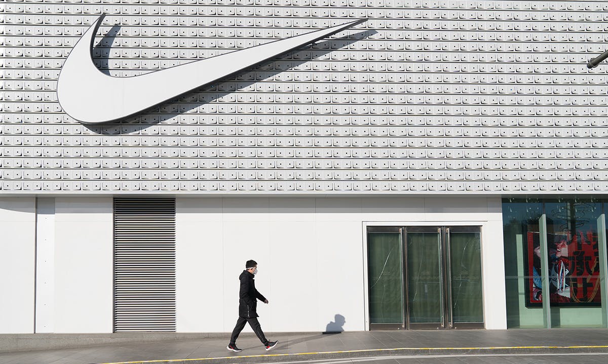 A man wearing a face mask walks past a Nike store in Central Business District, Beijing