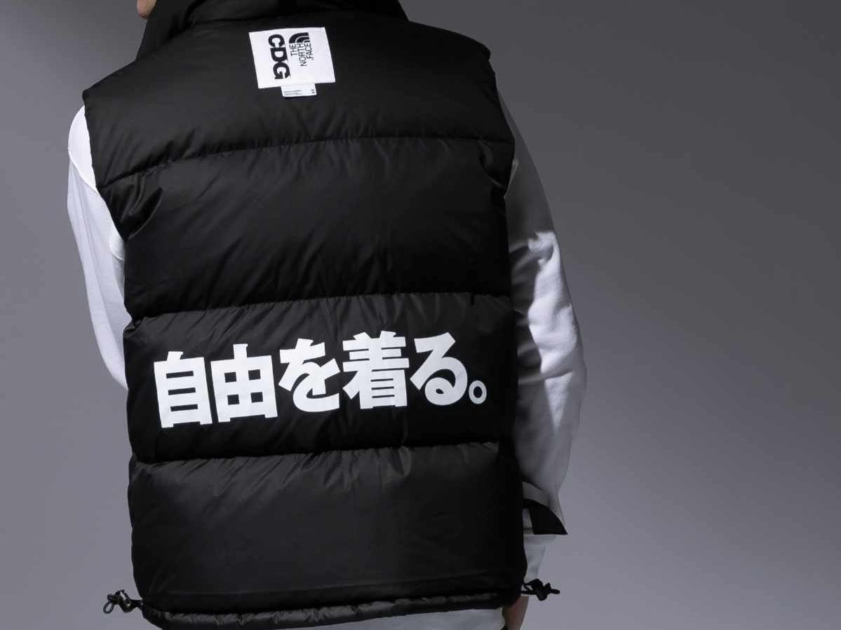 A male model wears the CDG x The North Face collaborative black jacket