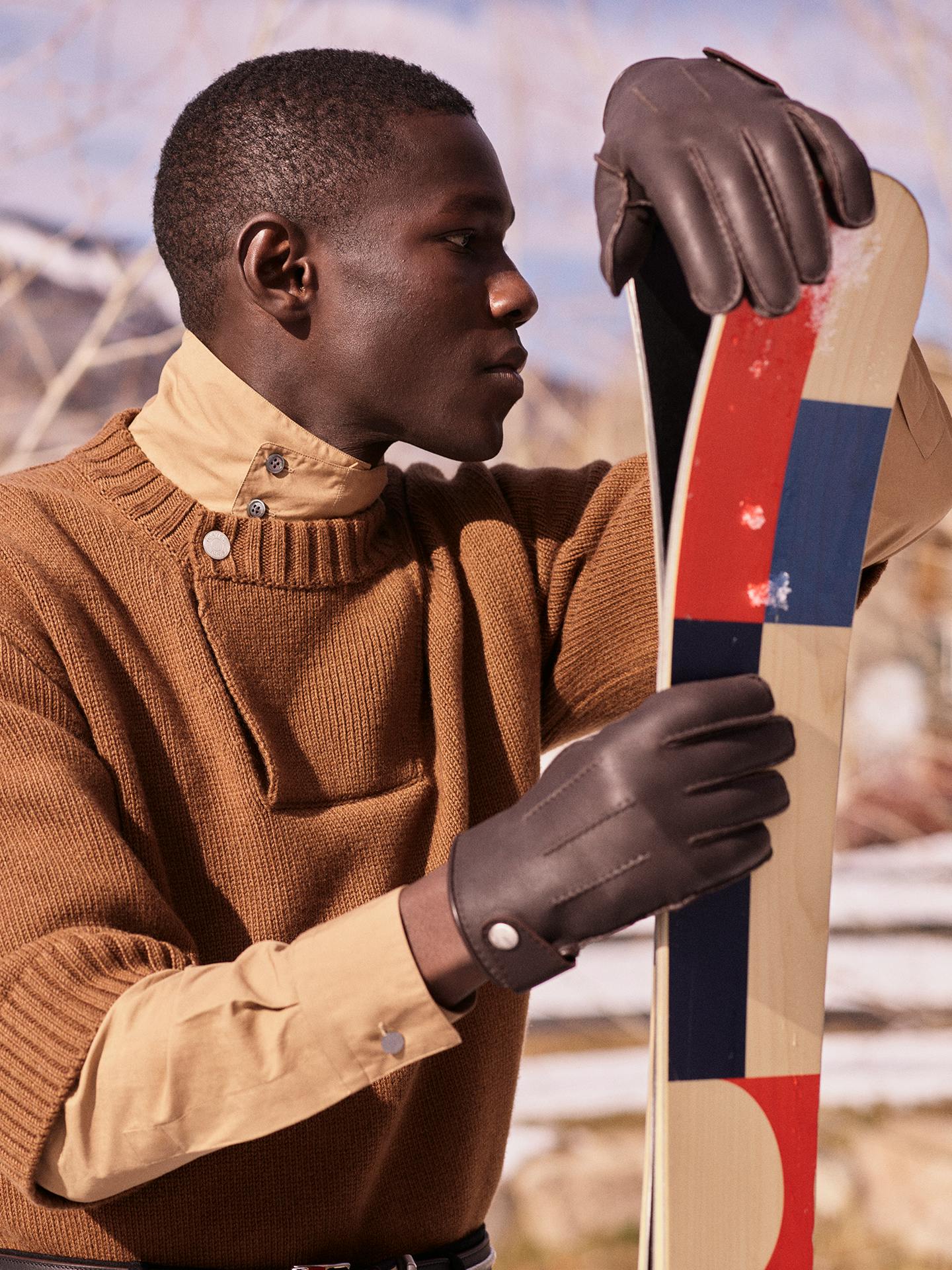 Model wearing knitwear, shirt, and leather gloves