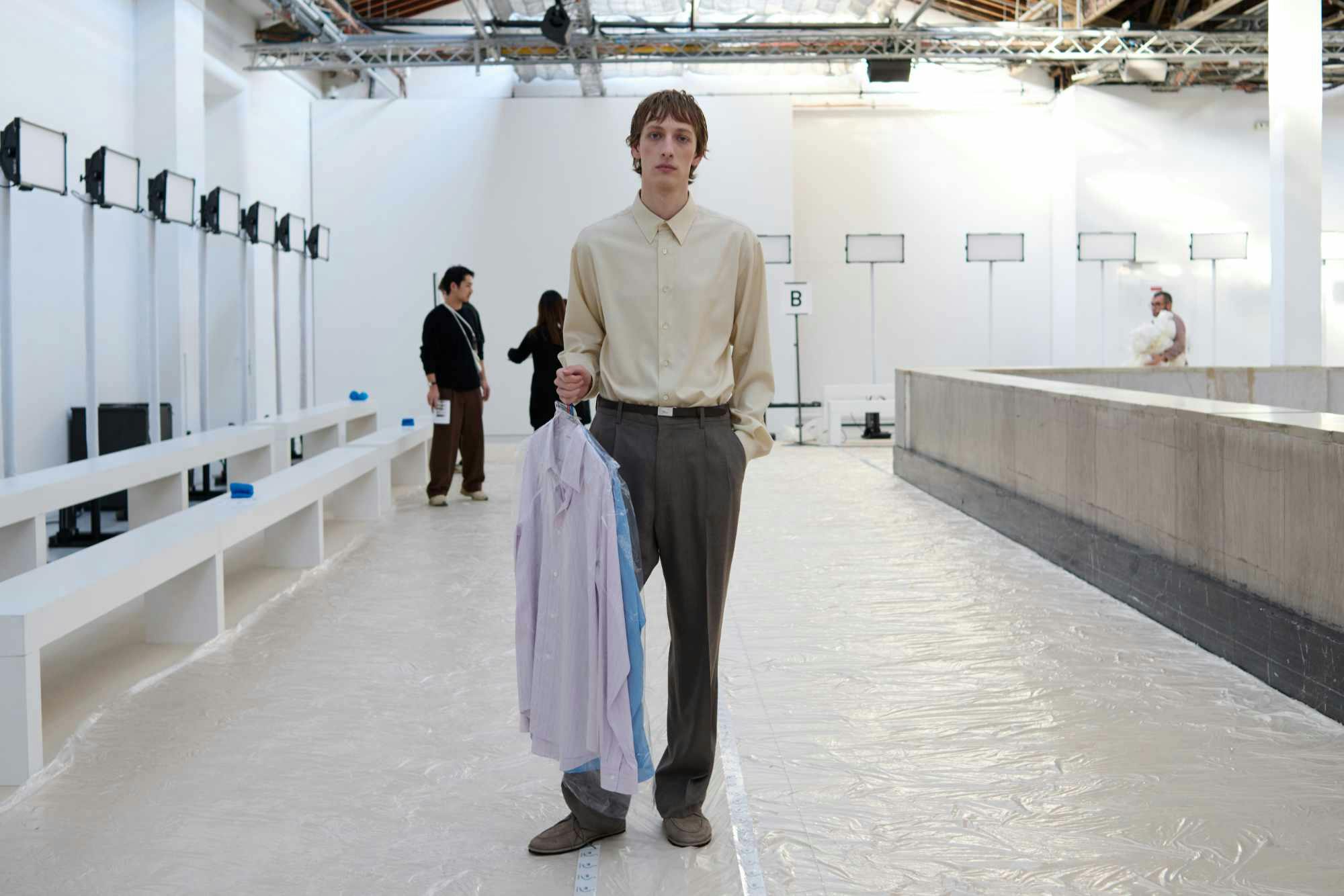 A model wears AURALEE's Fall/Winter 2024 shirt, slacks, and belt