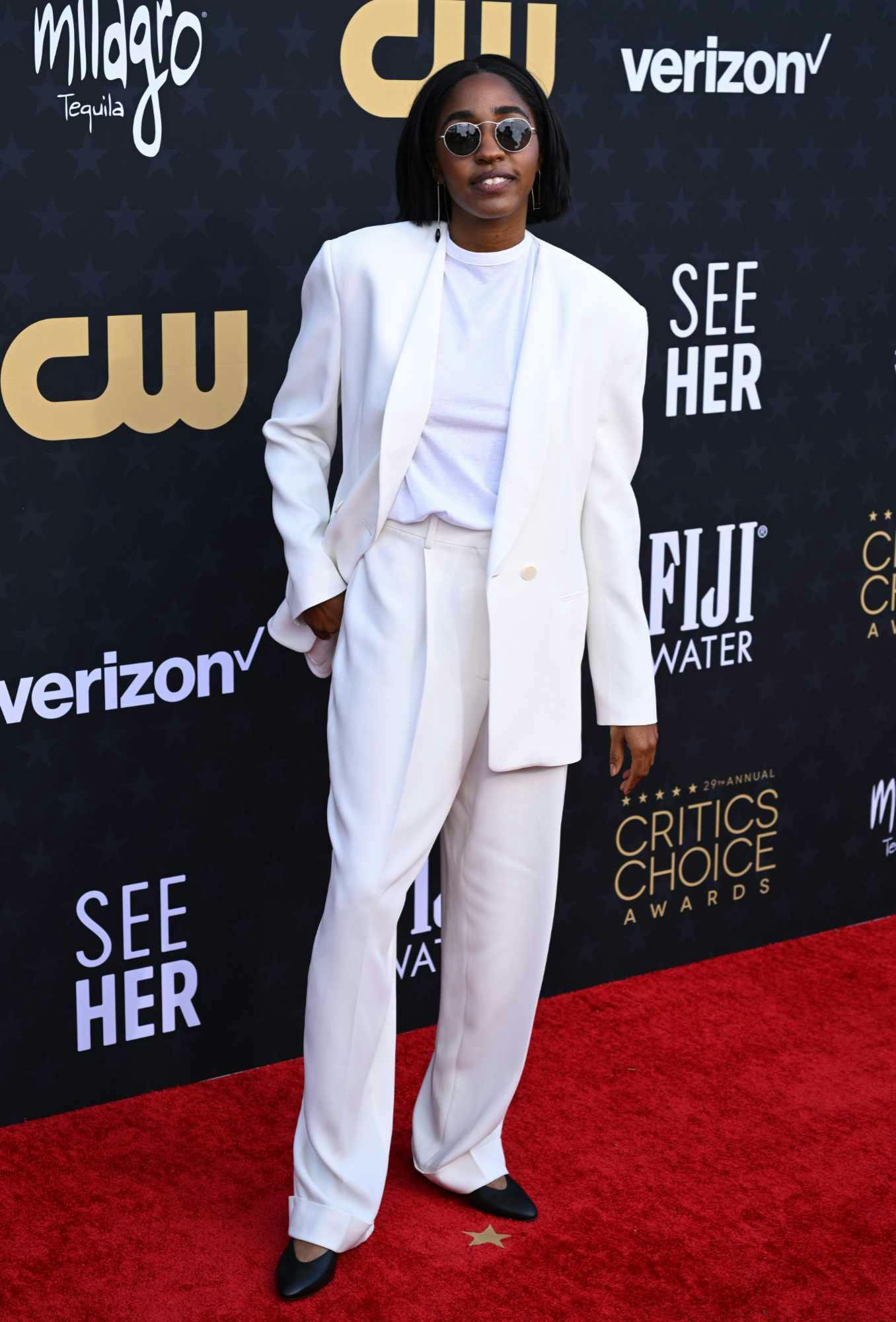 Ayo Edebiri wears a white suit & sunglasses