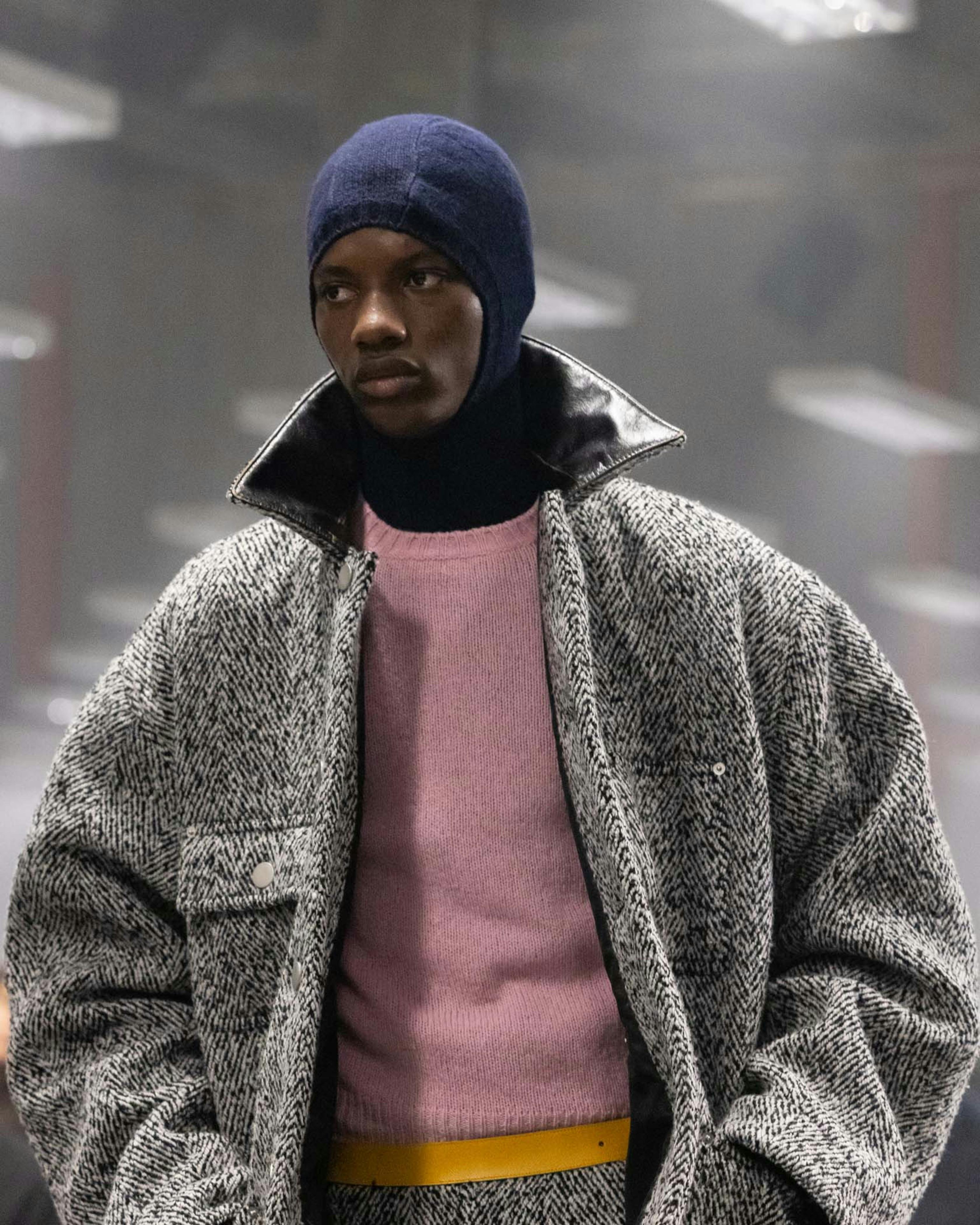 Models at Prada's Fall/Winter 2024 menswear runway show wear knit hoods and skullcaps