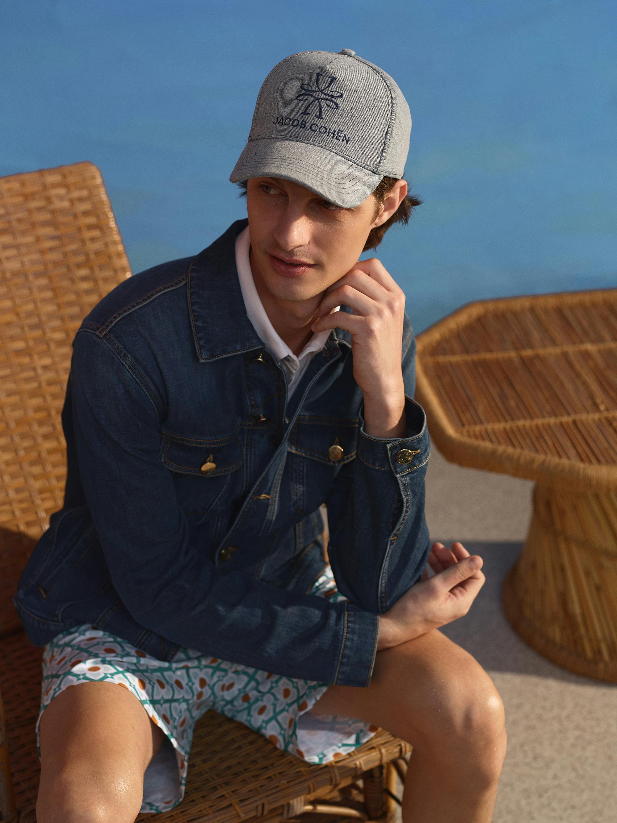 Model wears grey cap and denim jacket