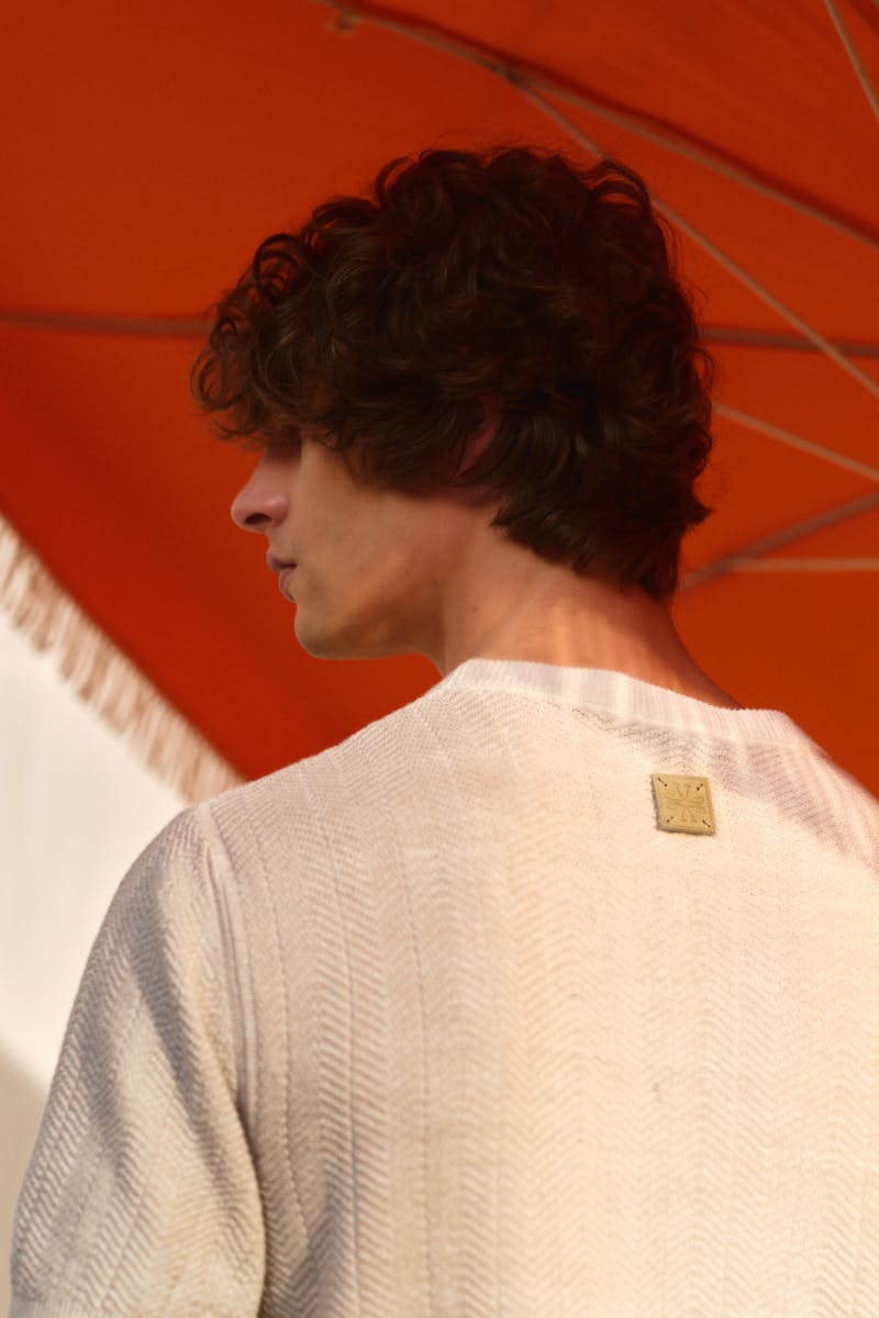 Shot from behind of a man wearing beige knitted pullover