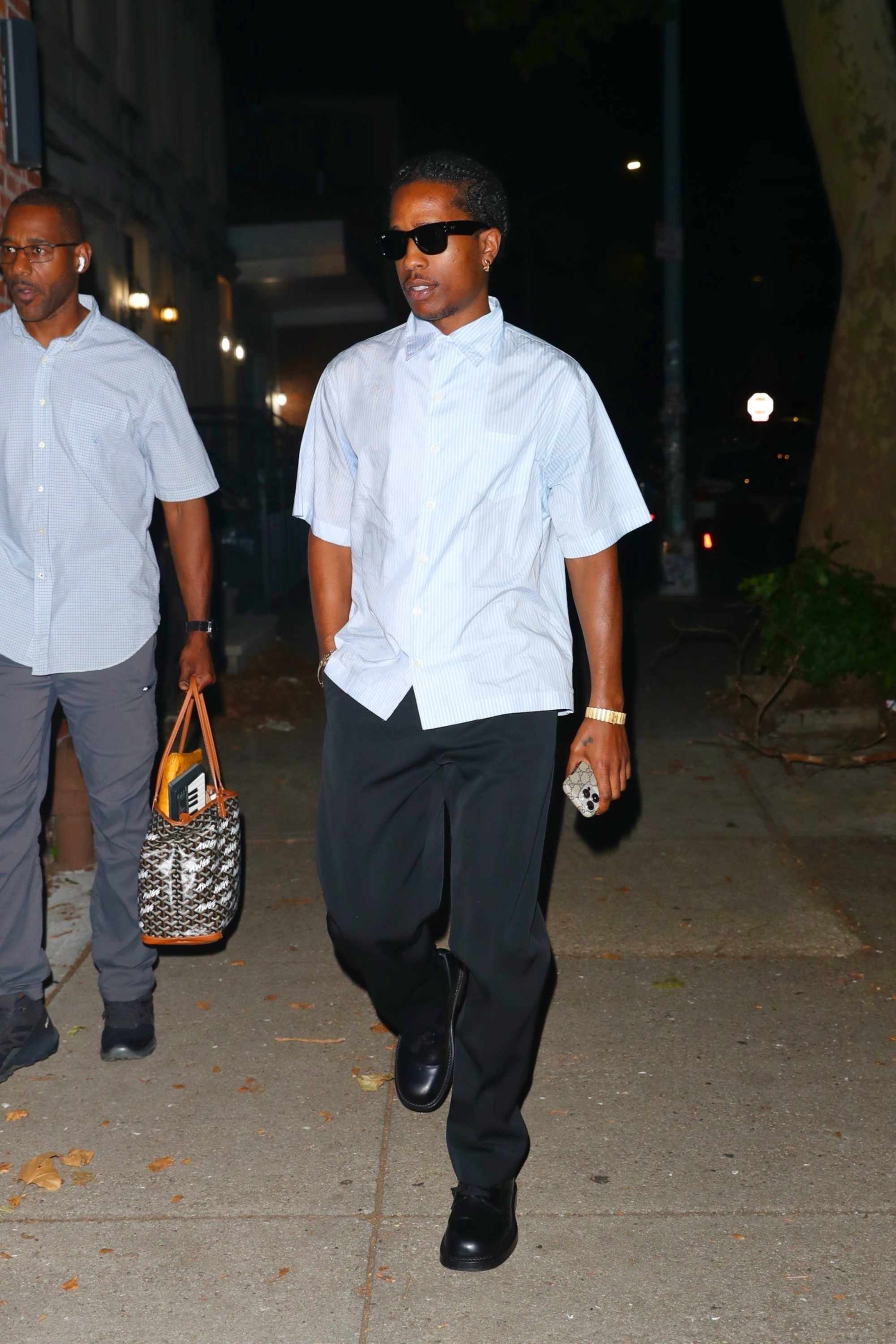 A$AP Rocky wears a short-sleeved white shirt, black pants, and black leather shoes while at a recording studio with Rihanna in July 2024