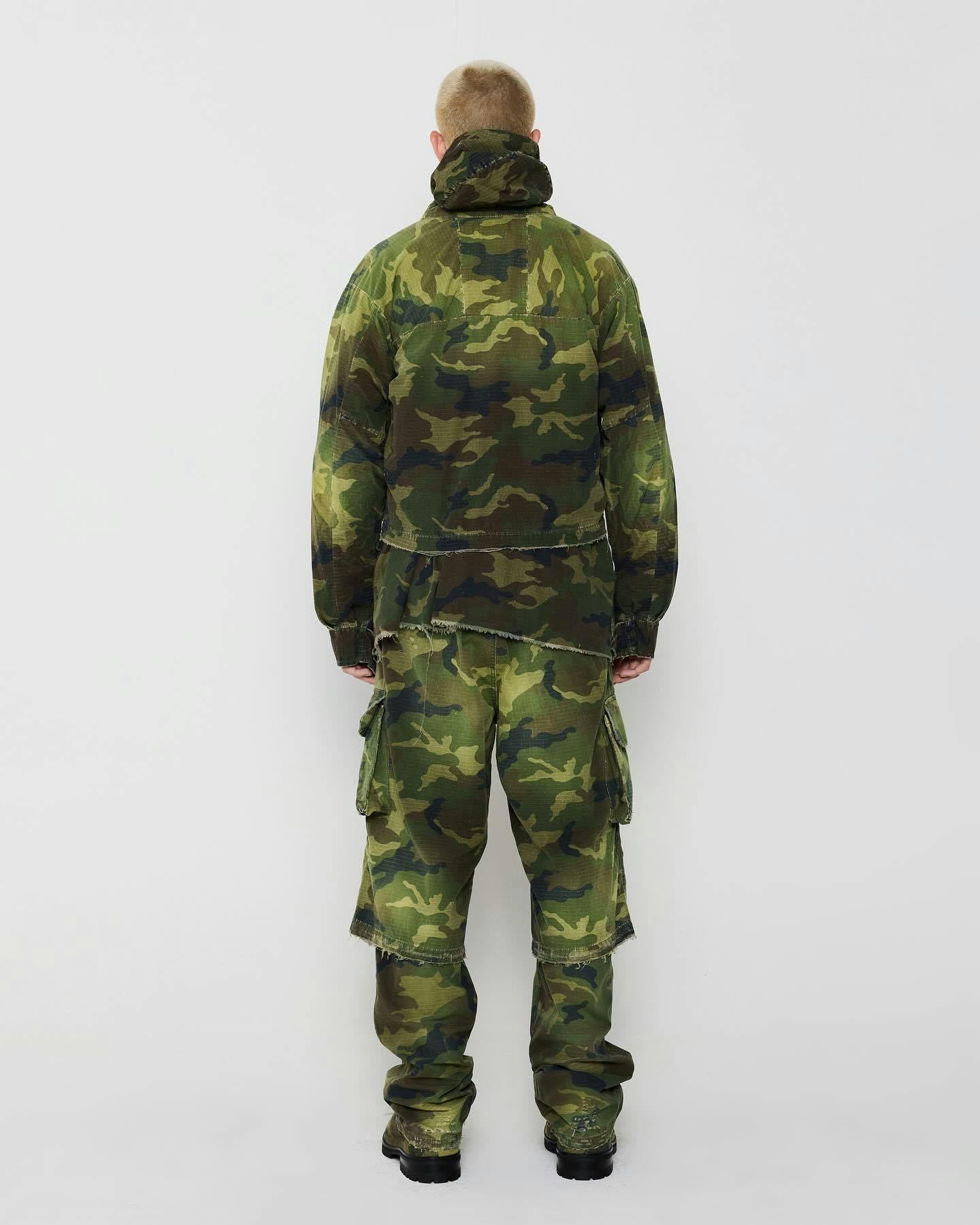 A model wears a camouflage 424 outfit, including camo shorts and camo pants