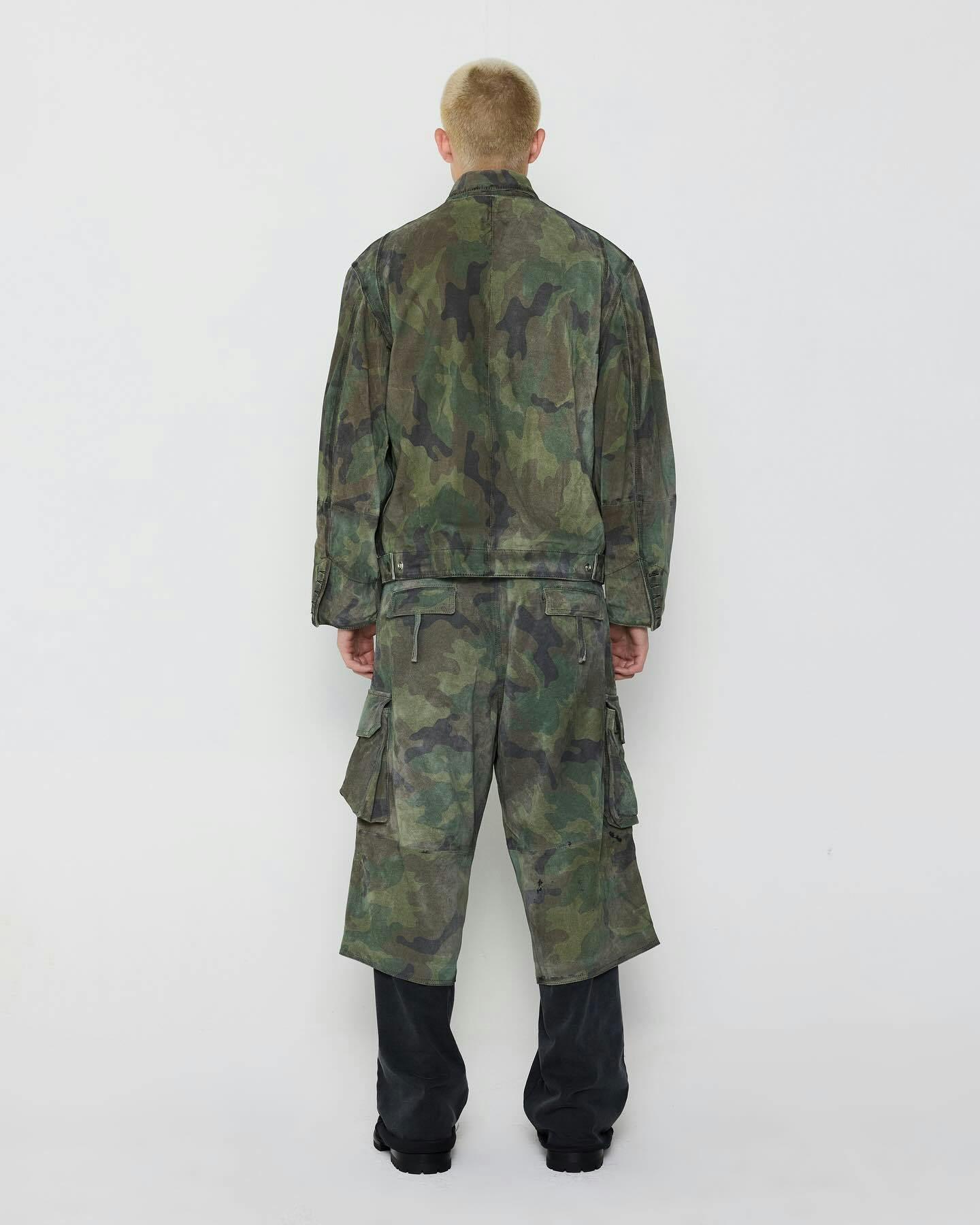 A model wears a camouflage 424 outfit, including camo shorts and camo pants