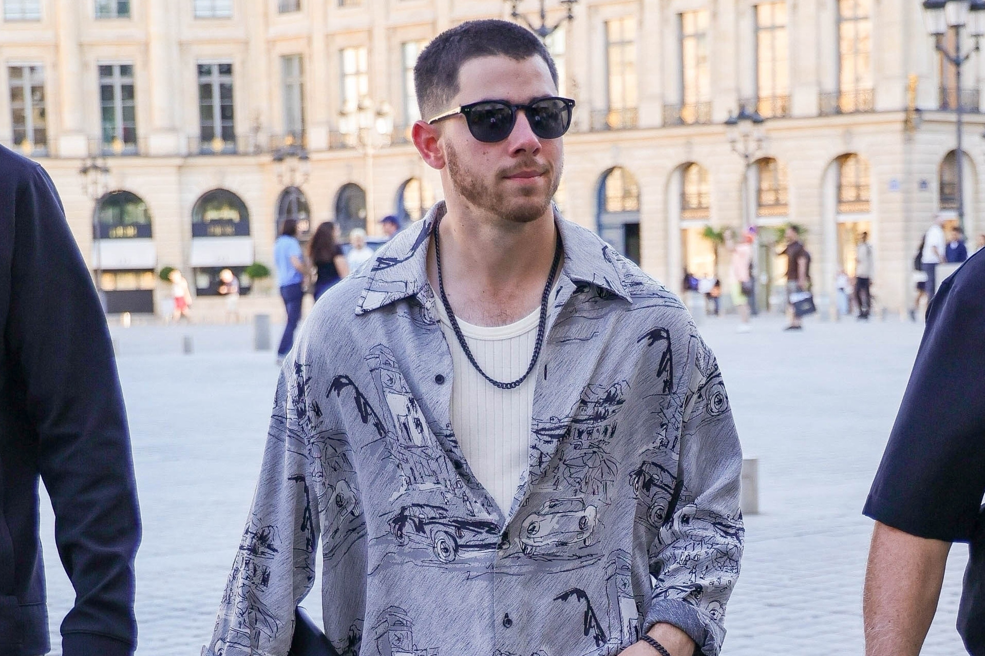 Nick Jonas carrying an Hermès Kelly Depeches 25 Clutch in Paris during the 2024 Olympics