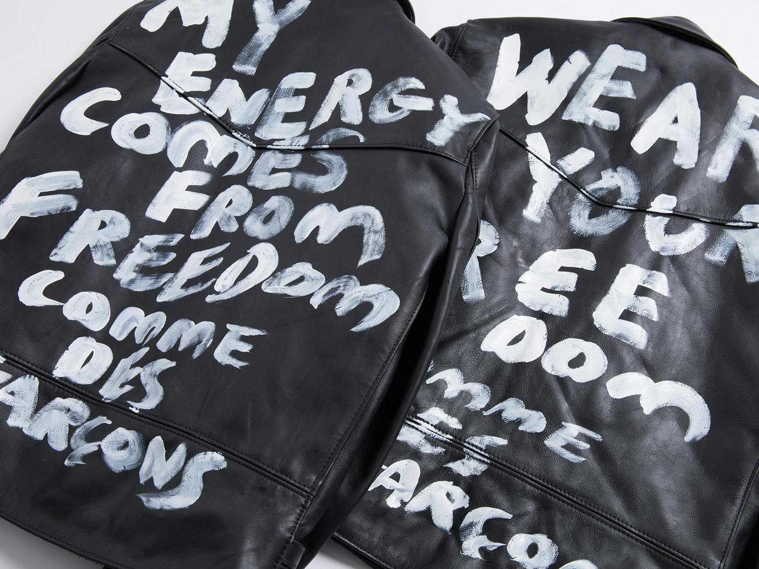 Comme des Garcons' Lewis Leathers jacket collab in black with white text