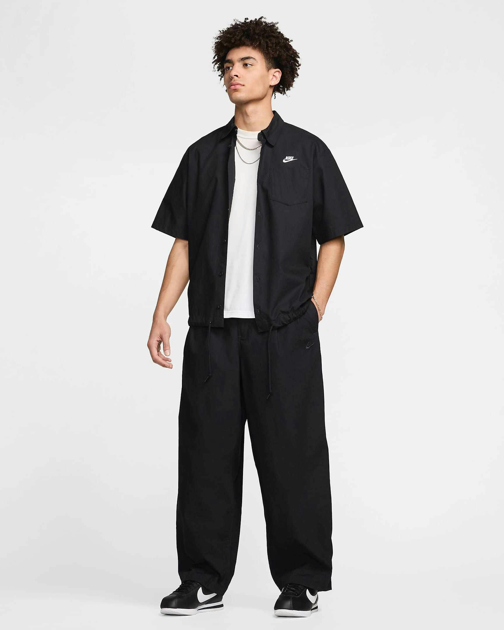 Nike Balloon Pant in beige and black colorways, with an elastic waist, pleats and loose leg