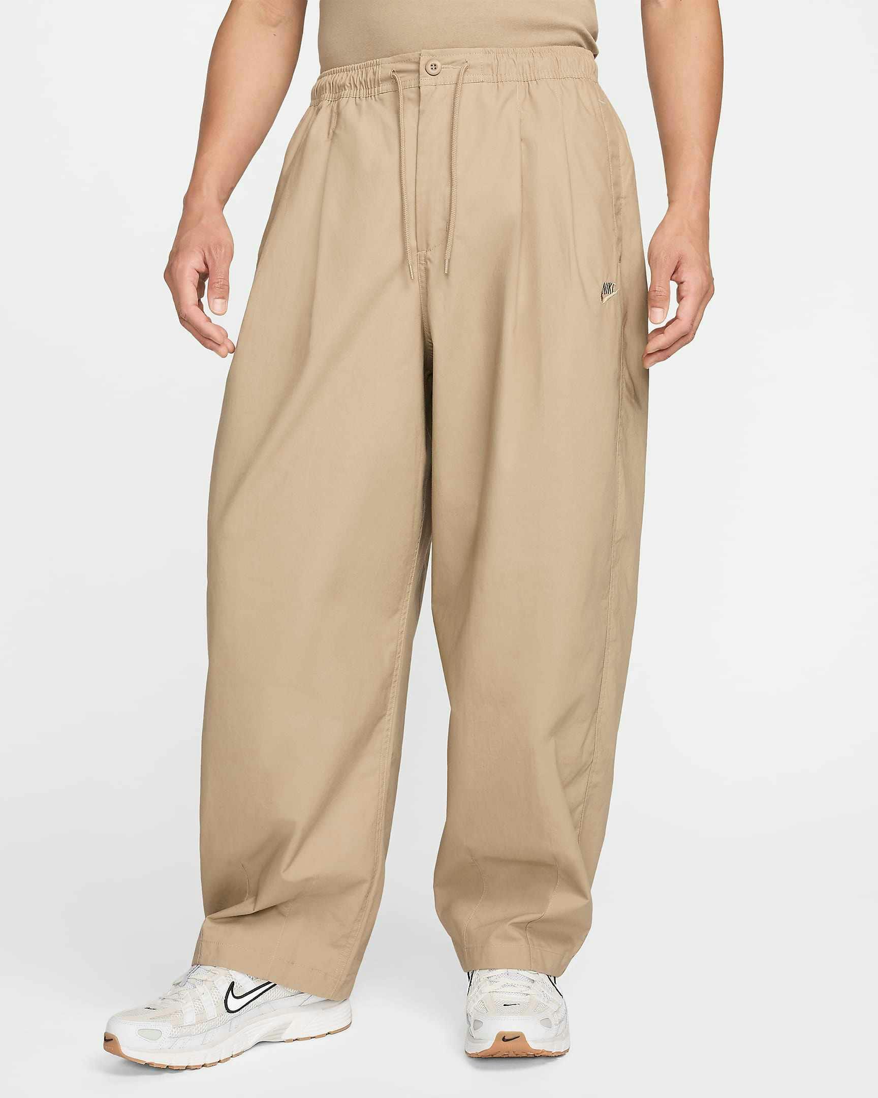 Nike Balloon Pant in beige and black colorways, with an elastic waist, pleats and loose leg