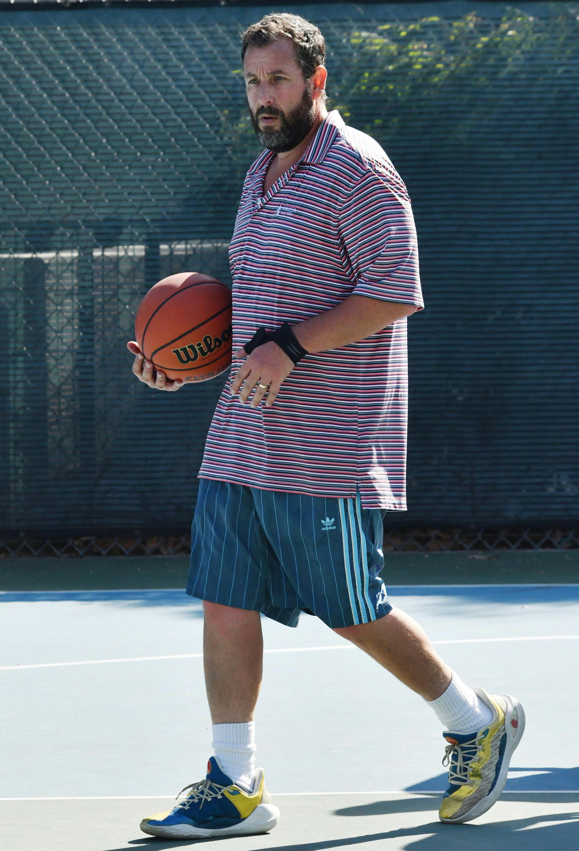 Adam Sandler wearing shorts while playing basketball on August 5, 2024