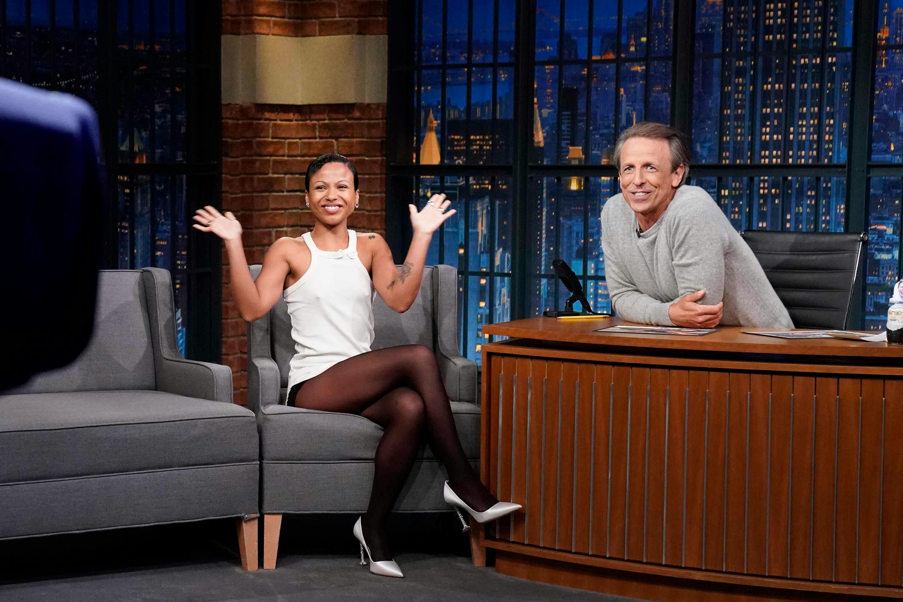 Myha'la wears white top and tights with white heels at seth myers talk show