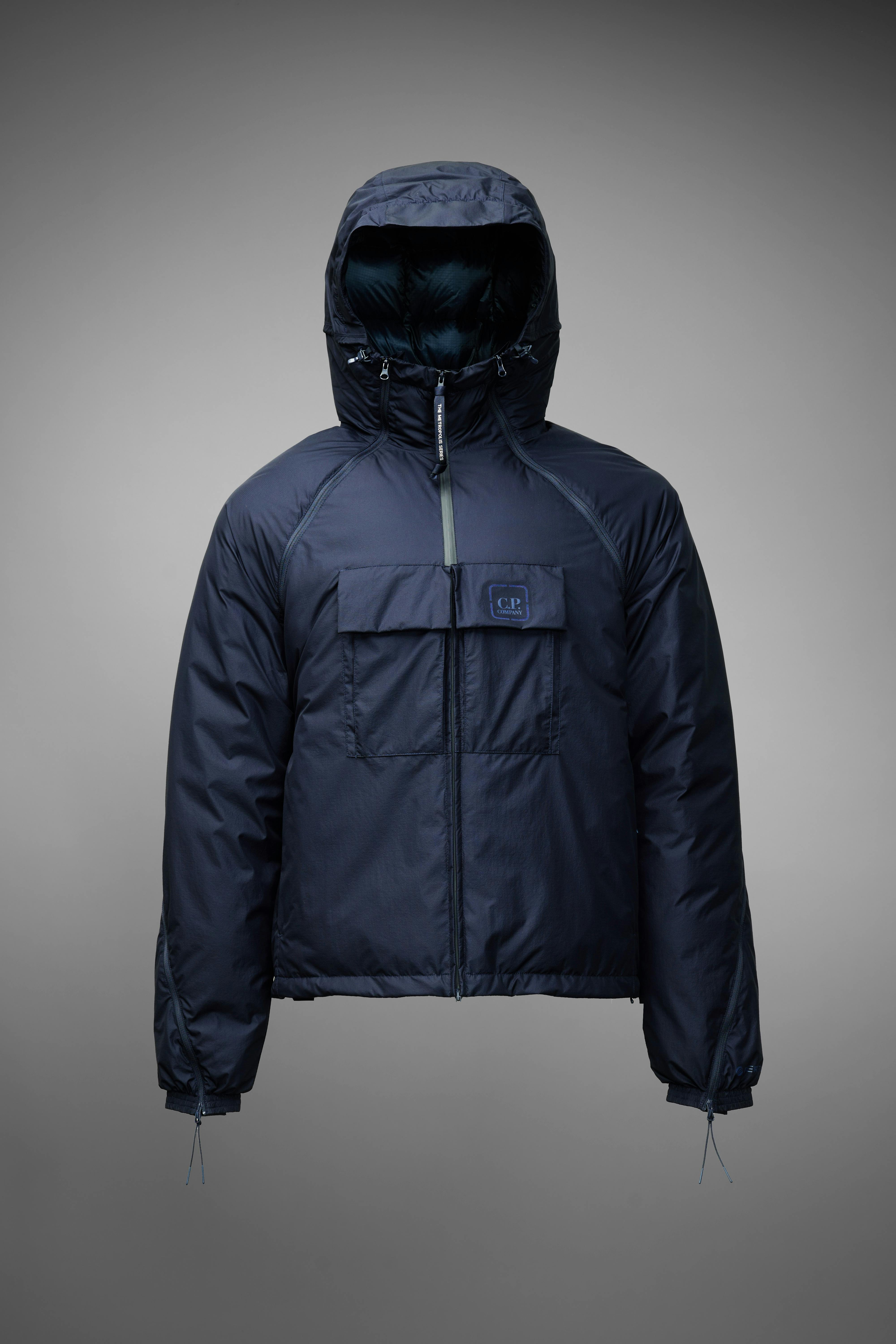 Product shot of a blue hooded utility jacket by C. P. Company