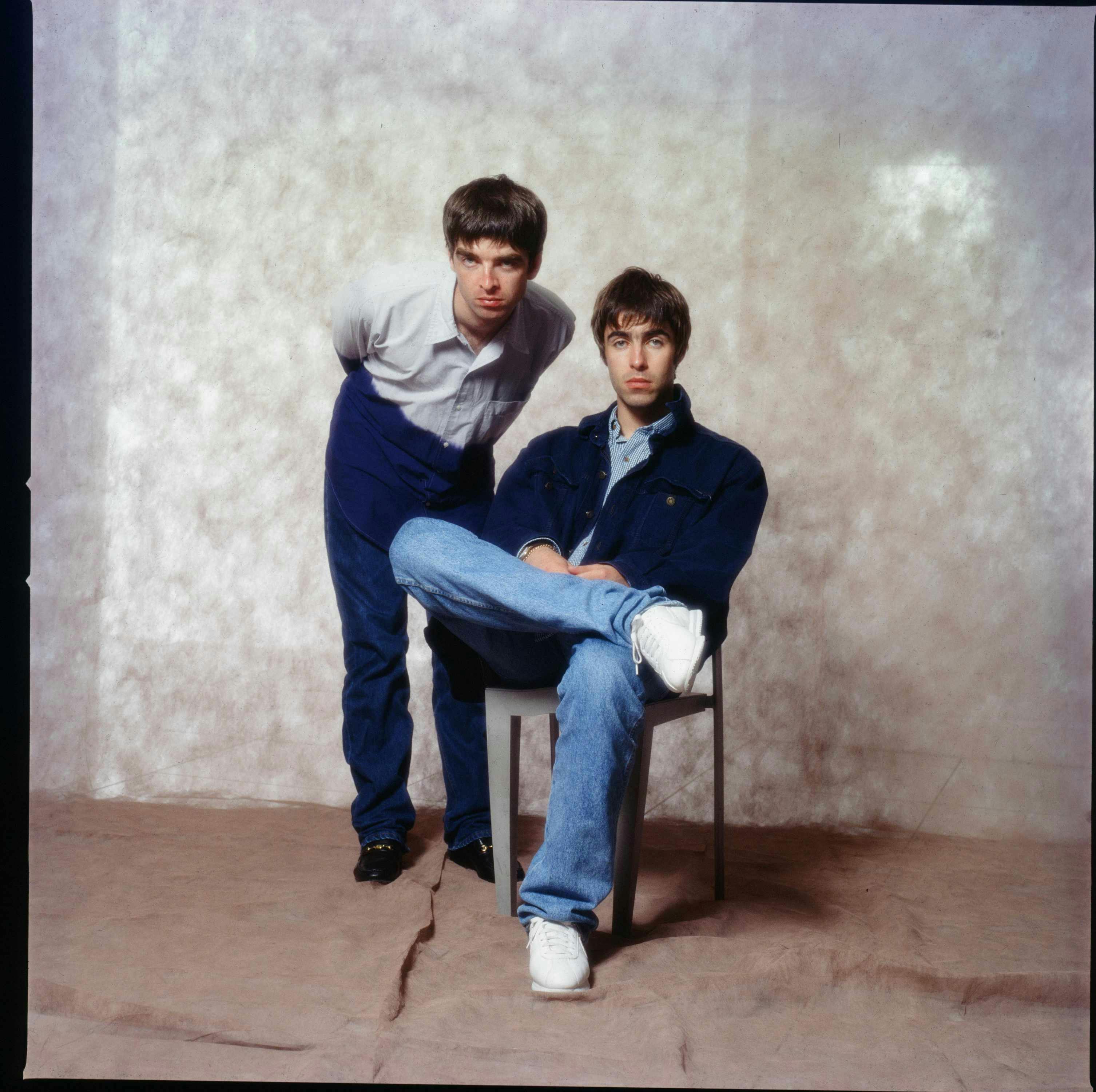 oasis band members liam and noel gallagher wear blue jeans