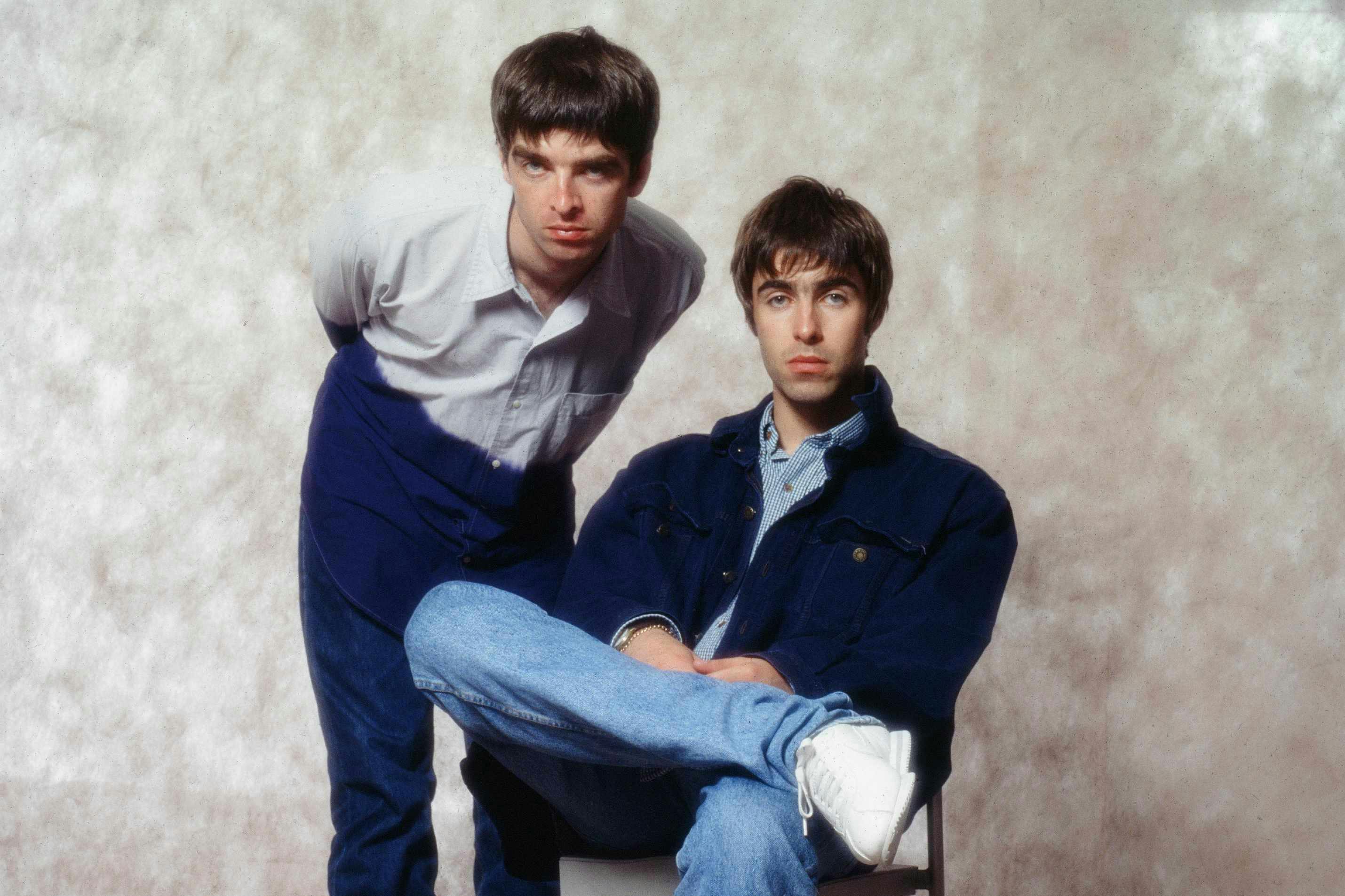 oasis band members liam and noel gallagher wear blue jeans