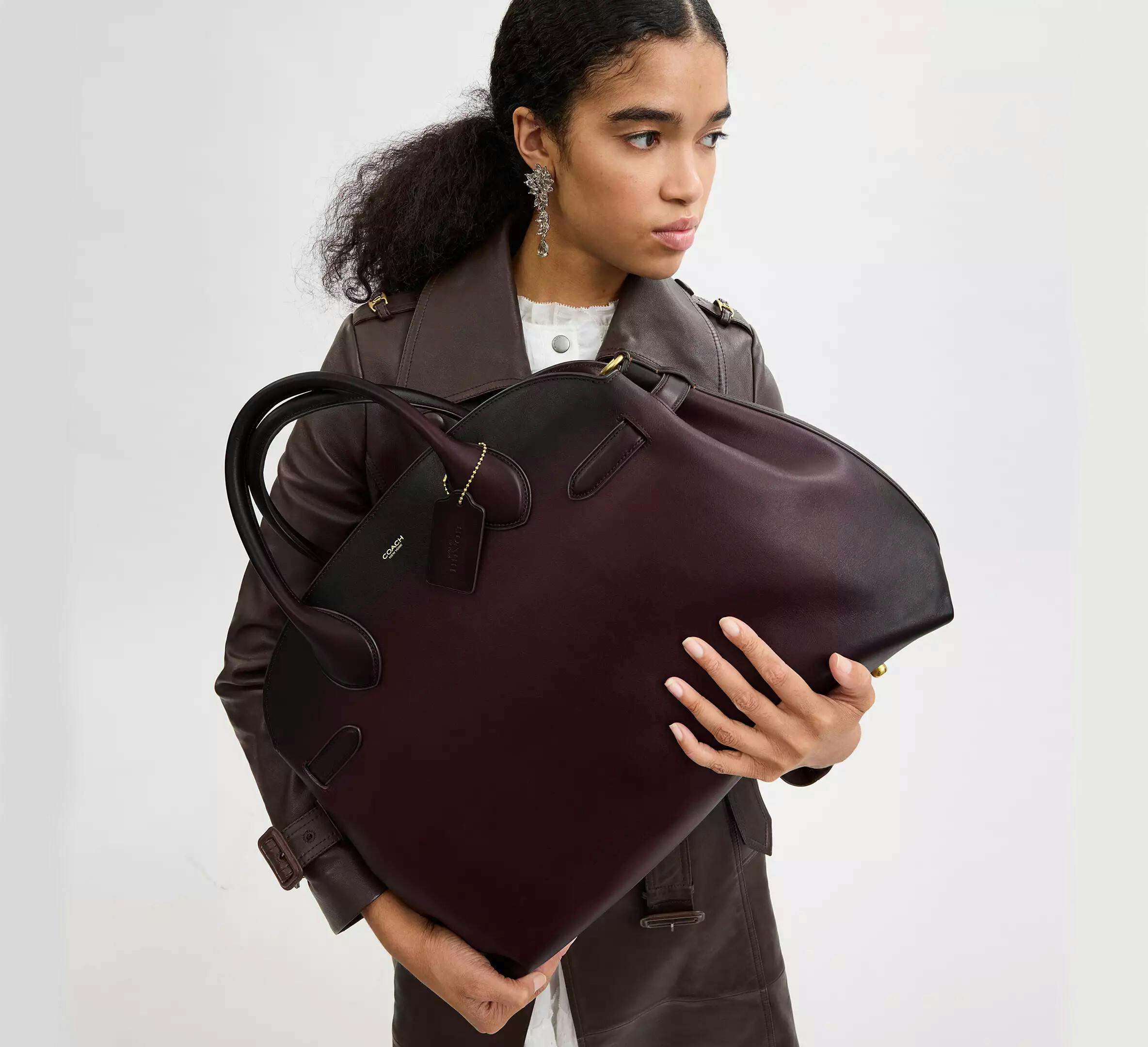 Woman holding Coach Empire Carryall.