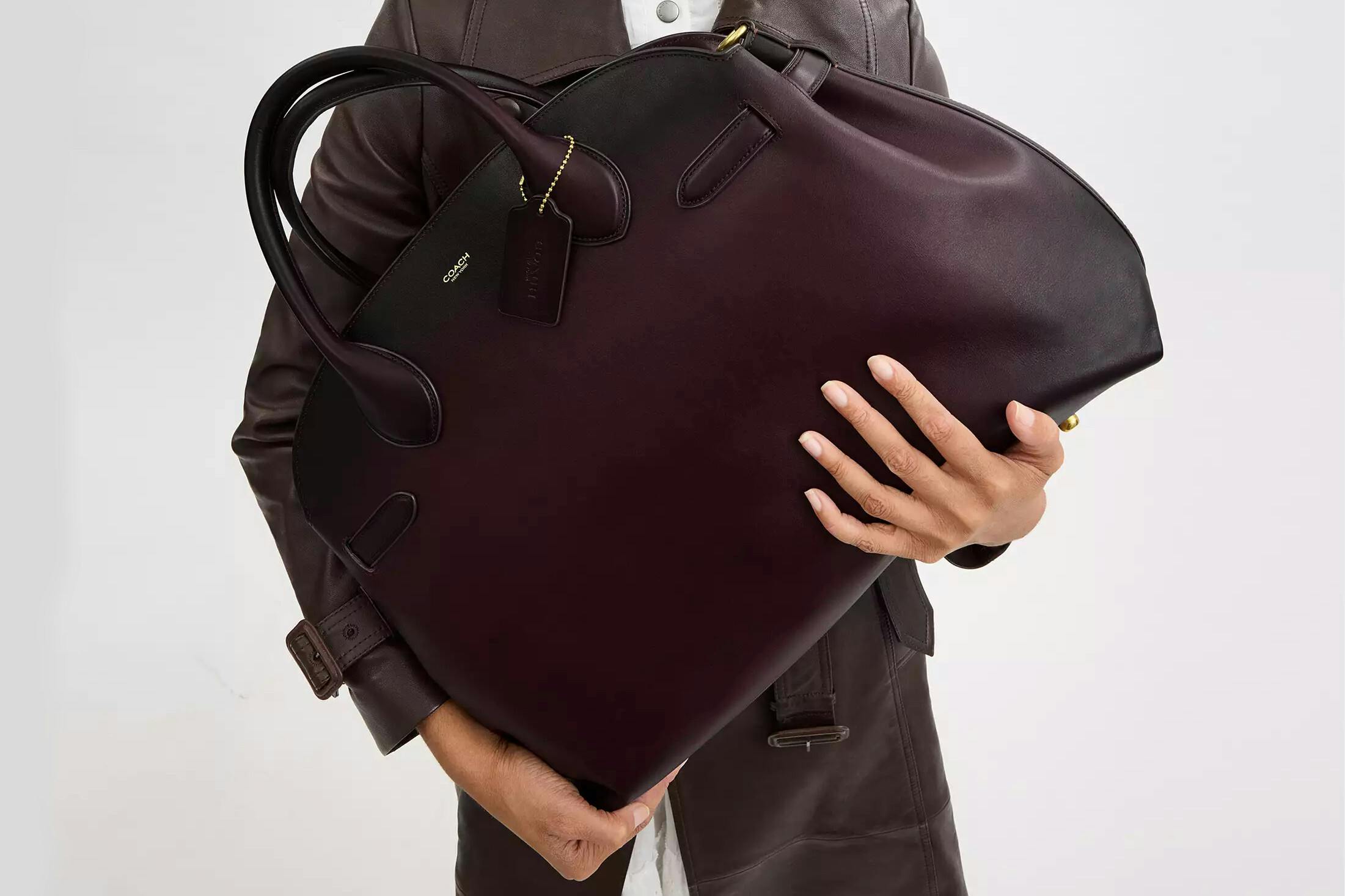 Woman holding Coach Empire Carryall.