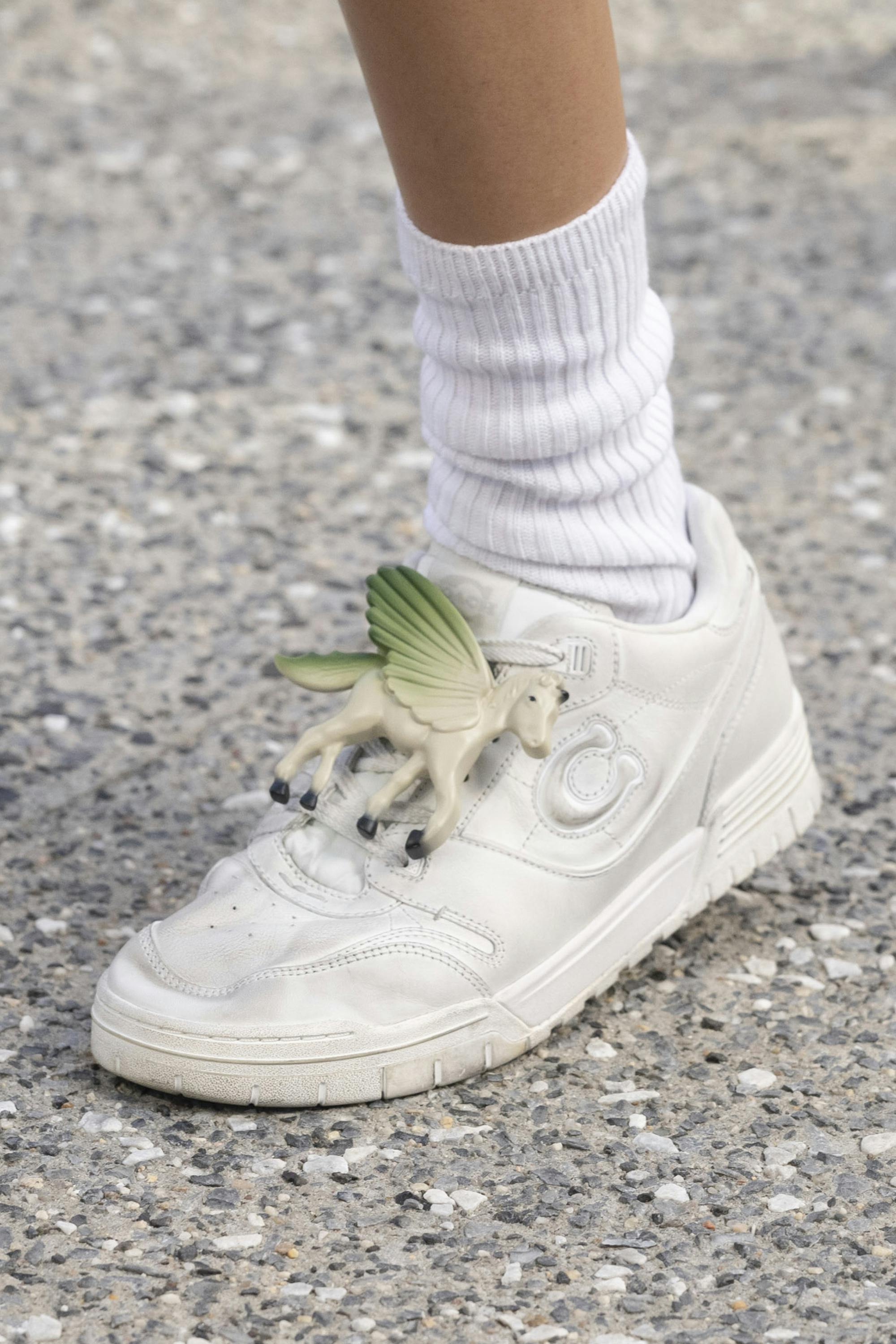 A unicorn-shaped charm on a sneaker at Coach's Spring/Summer 2025 runway show