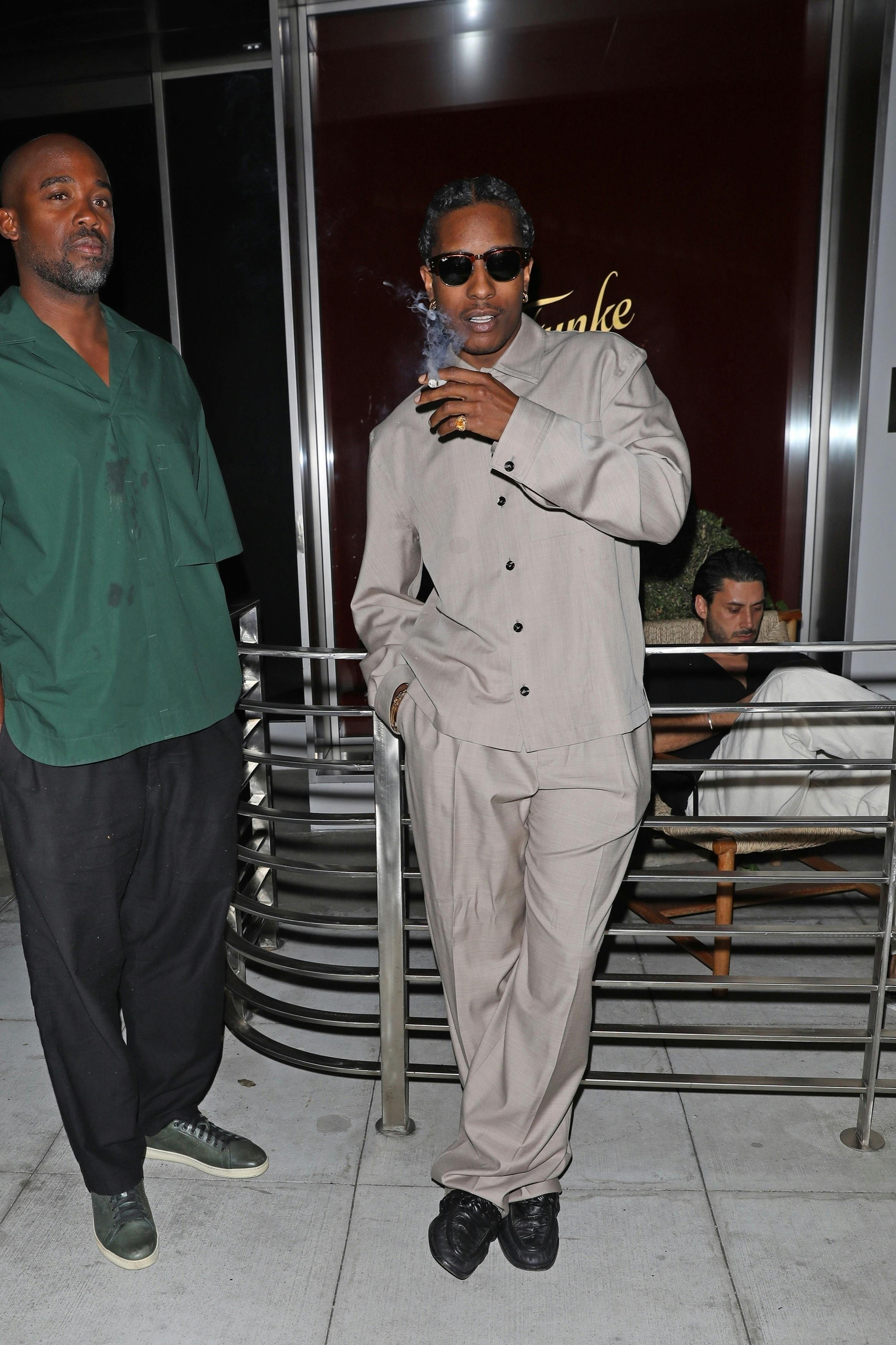 Asap rocky wears grey bottega shirt and slacks with black loafers and sunglasses at funke in los angeles