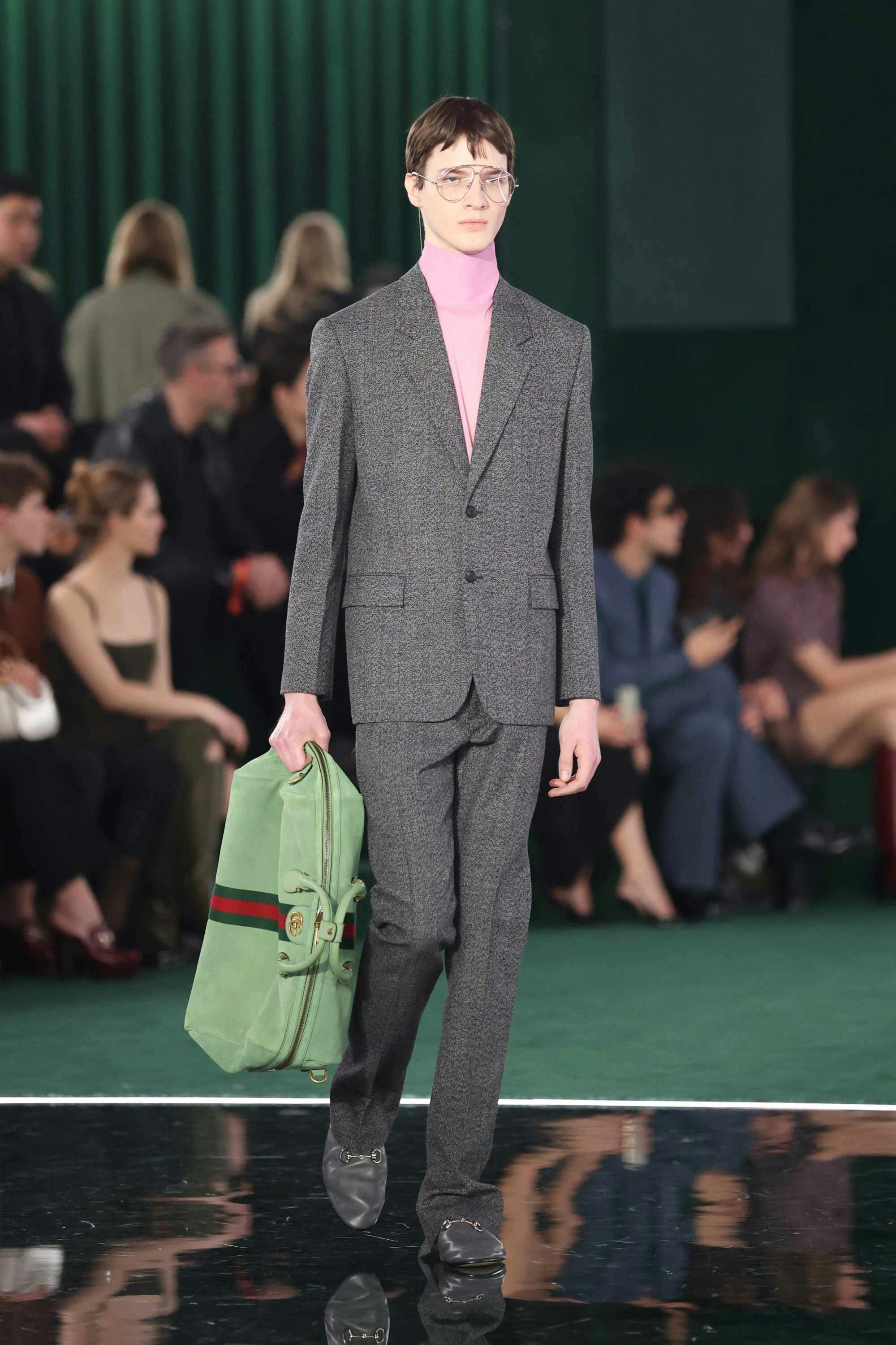 gucci fw25 male models hold duffle bags vertically