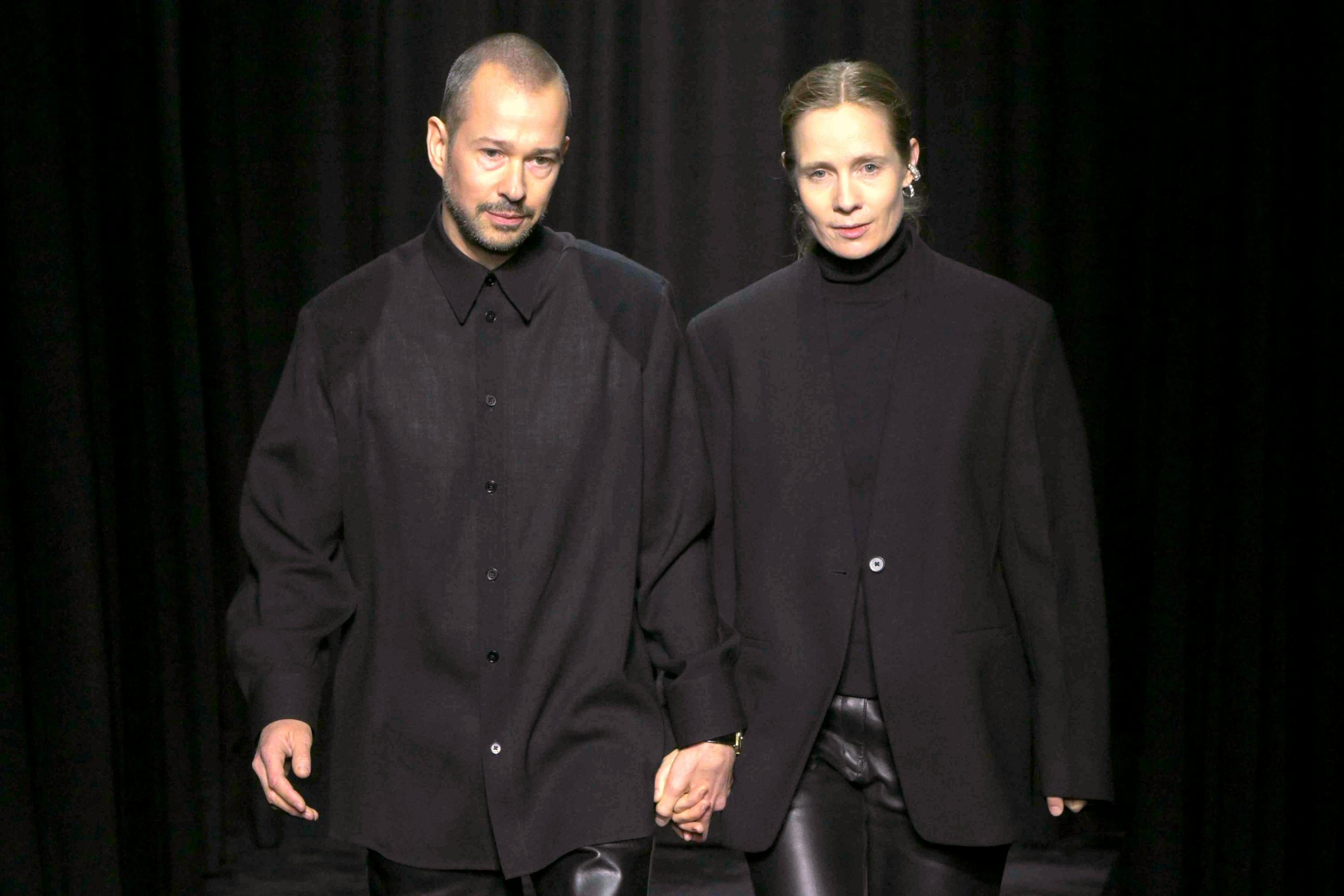 jil sander creative directors luke and lucie meier hold hands at their fall/winter 2025 fashion show